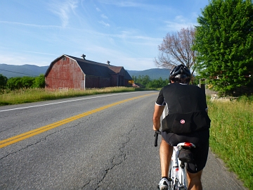 Cyclist approaching old barn